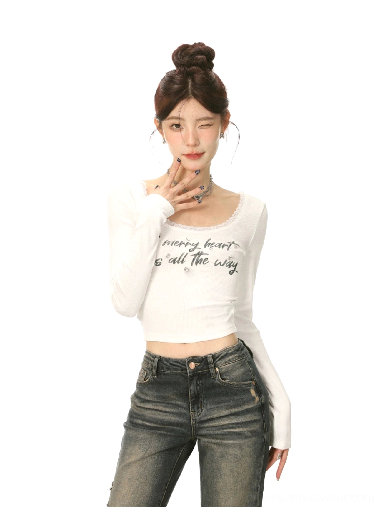 Front close-up of a white lace trim U-neck cropped long-sleeve streetwear top with handwritten lettering and a fitted waist-exposing silhouette