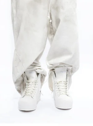 White leather high-top boots styled with oversized off-white cargo pants for a minimalist Korean streetwear outfit