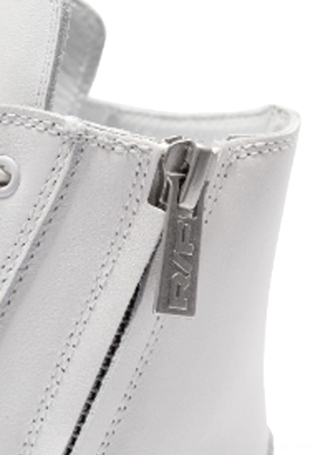 Close-up side view of white leather high-top boot zipper hardware and precision stitching around the ankle opening
