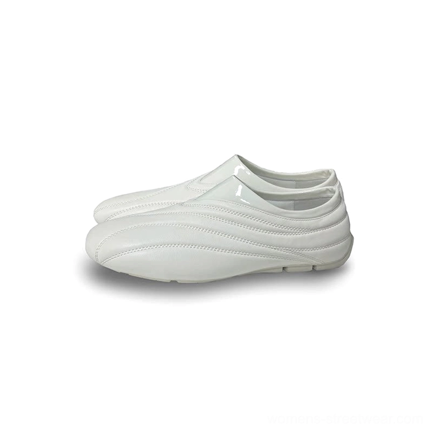 White low-profile leather slip-on shoes with matching wave stitching, glossy collar trim, and flat rubber sole