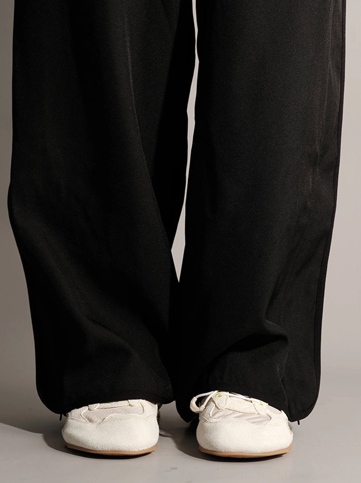 White low-profile casual nubuck trainers styled with black wide-leg trousers