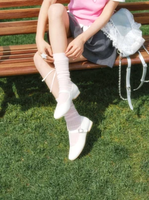 White Mary Jane ballet flats with adjustable silver buckle strap styled with a pink top grey skirt and ruffled socks