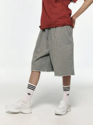 White chunky mesh runner sneakers styled with striped crew socks and casual streetwear shorts