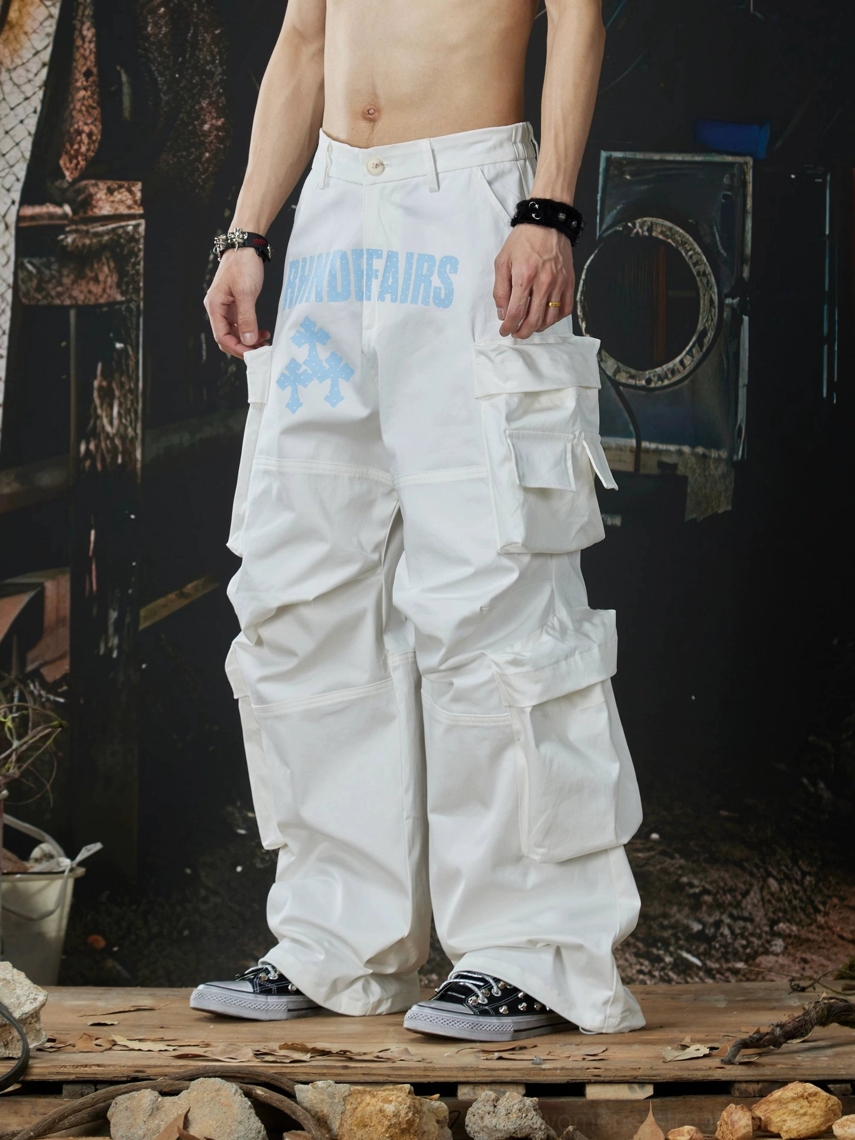 White multi-pocket wide-leg cargo pants side front view highlighting stacked utility pockets and contrast hip print