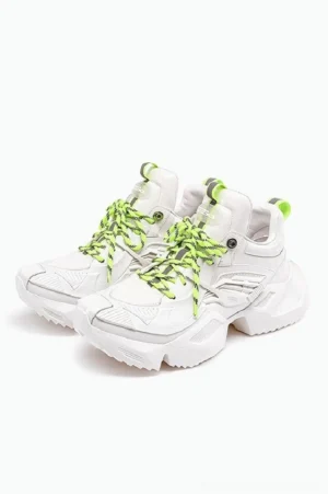 White and neon green 3D-printed platform sneakers shown as a paired front oblique view with geometric uppers, striped laces, bright heel pull tabs, and thick jagged streetwear outsoles