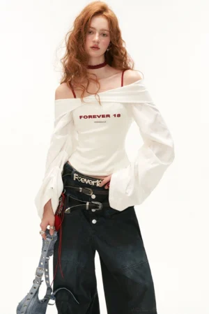 Full-body styling of white off-shoulder bell sleeve crop top with wide-leg denim jeans statement belts and streetwear accessories