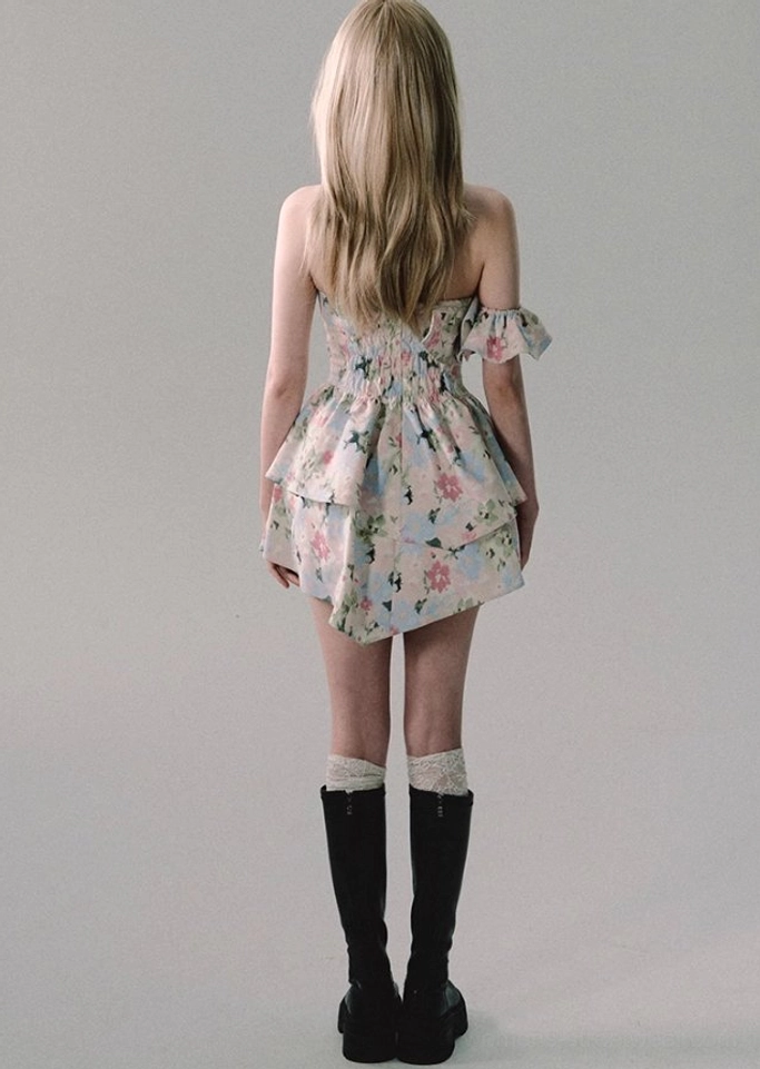White off-shoulder floral mini dress showcasing layered ruffle skirt, sweetheart bodice, removable sleeves, and expressive Korean fashion styling