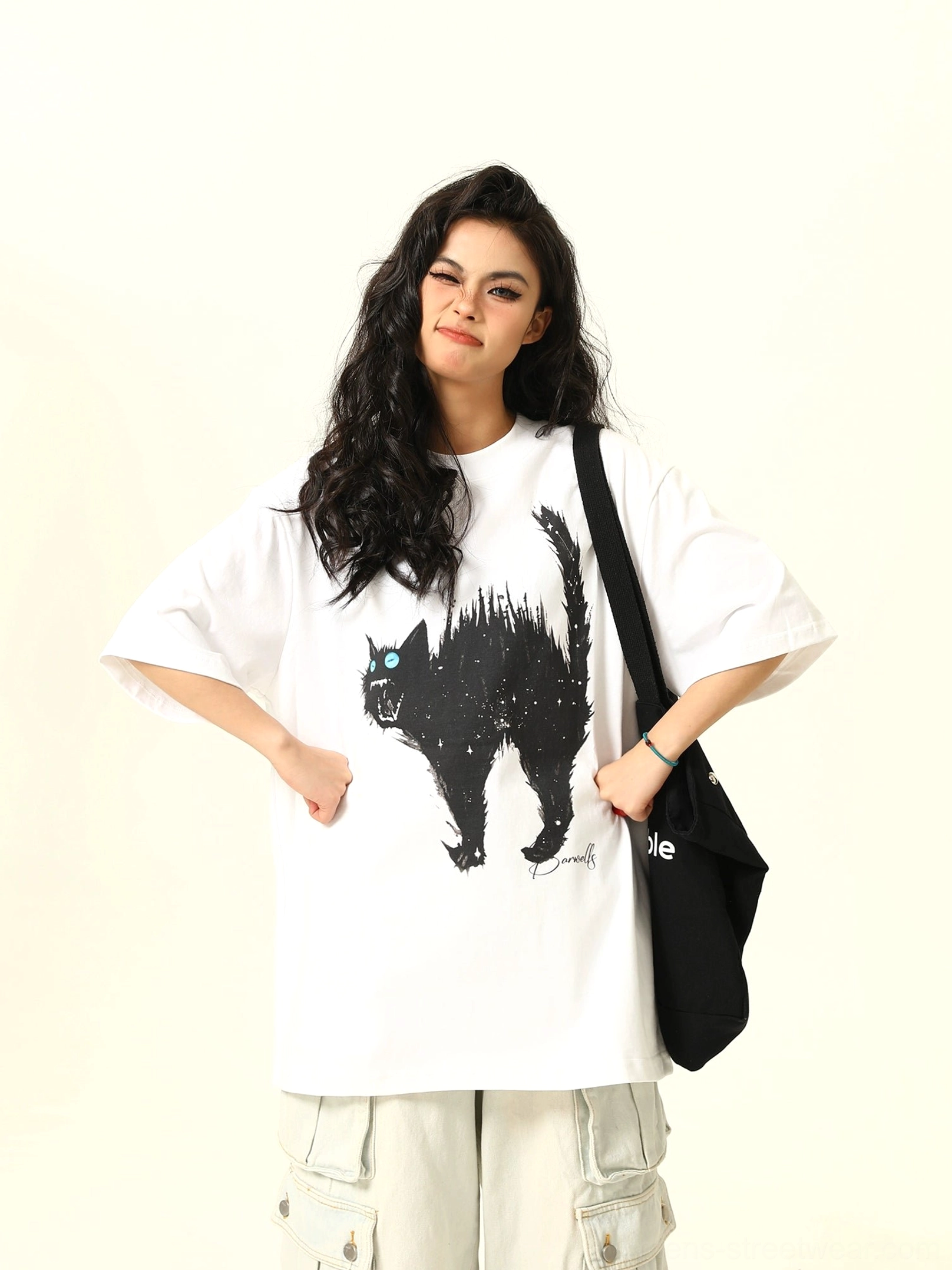 Full-body front view of a white oversized cat graphic T-shirt with black angry cat illustration, loose fit, light gray cargo pants, and tote bag