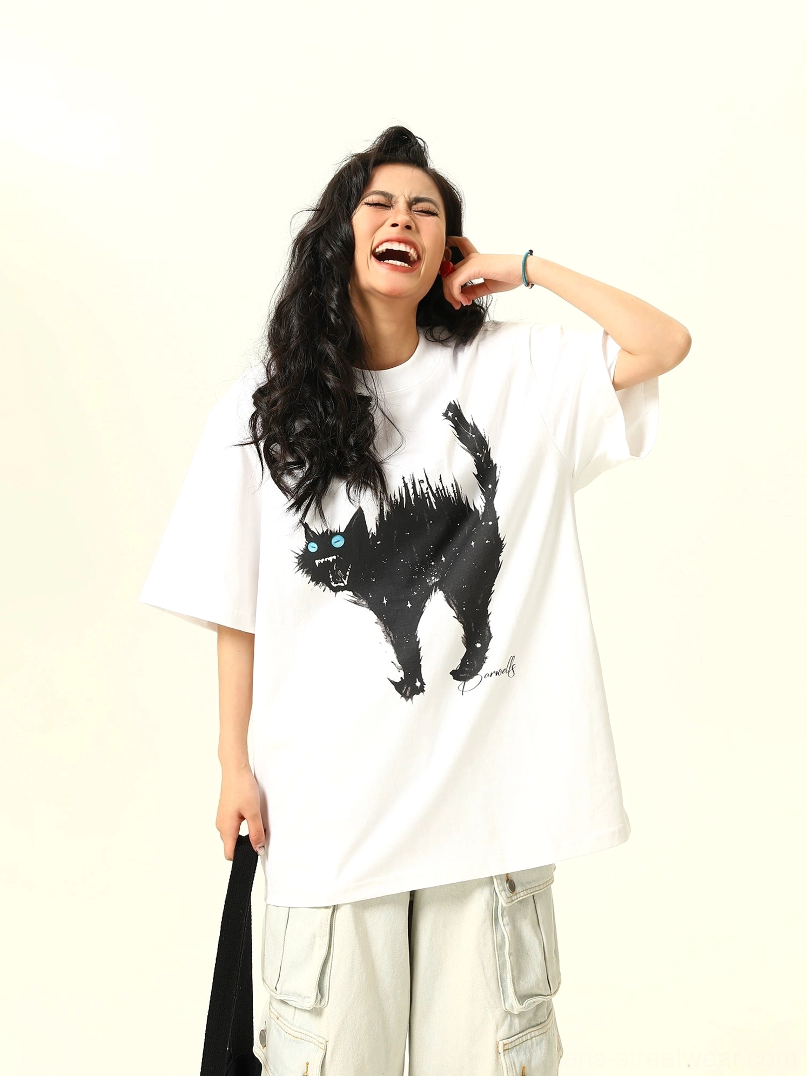 Three-quarter front view of a white oversized streetwear cat T-shirt with black sketch-style cat print and electric blue eyes