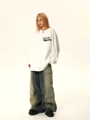 White oversized graphic long sleeve streetwear tee shown from a three-quarter view with black graffiti chest lettering