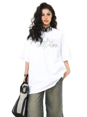 Back three-quarter view of white oversized graphic T-shirt with retro lettering print styled with wide-leg jeans and sporty bag