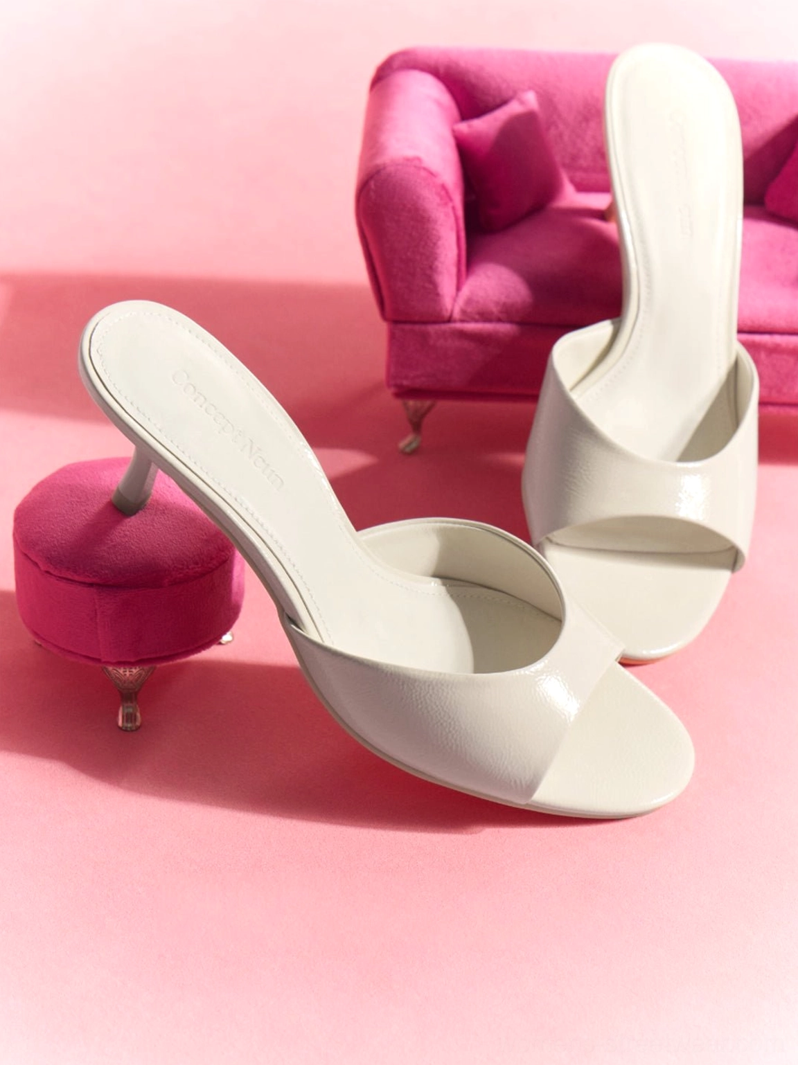 Pair of white patent open-toe kitten-heel mule slides styled with minimalist retro decor