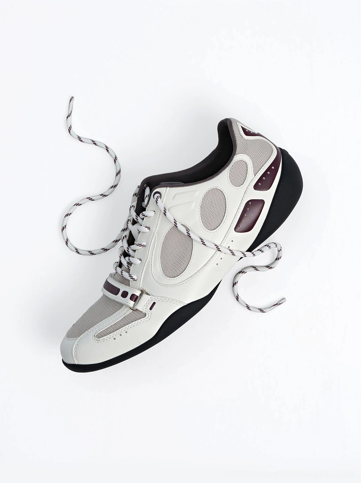 Angled top view of a white perforated retro sport sneaker with loose laces burgundy contrast trim and dark outsole
