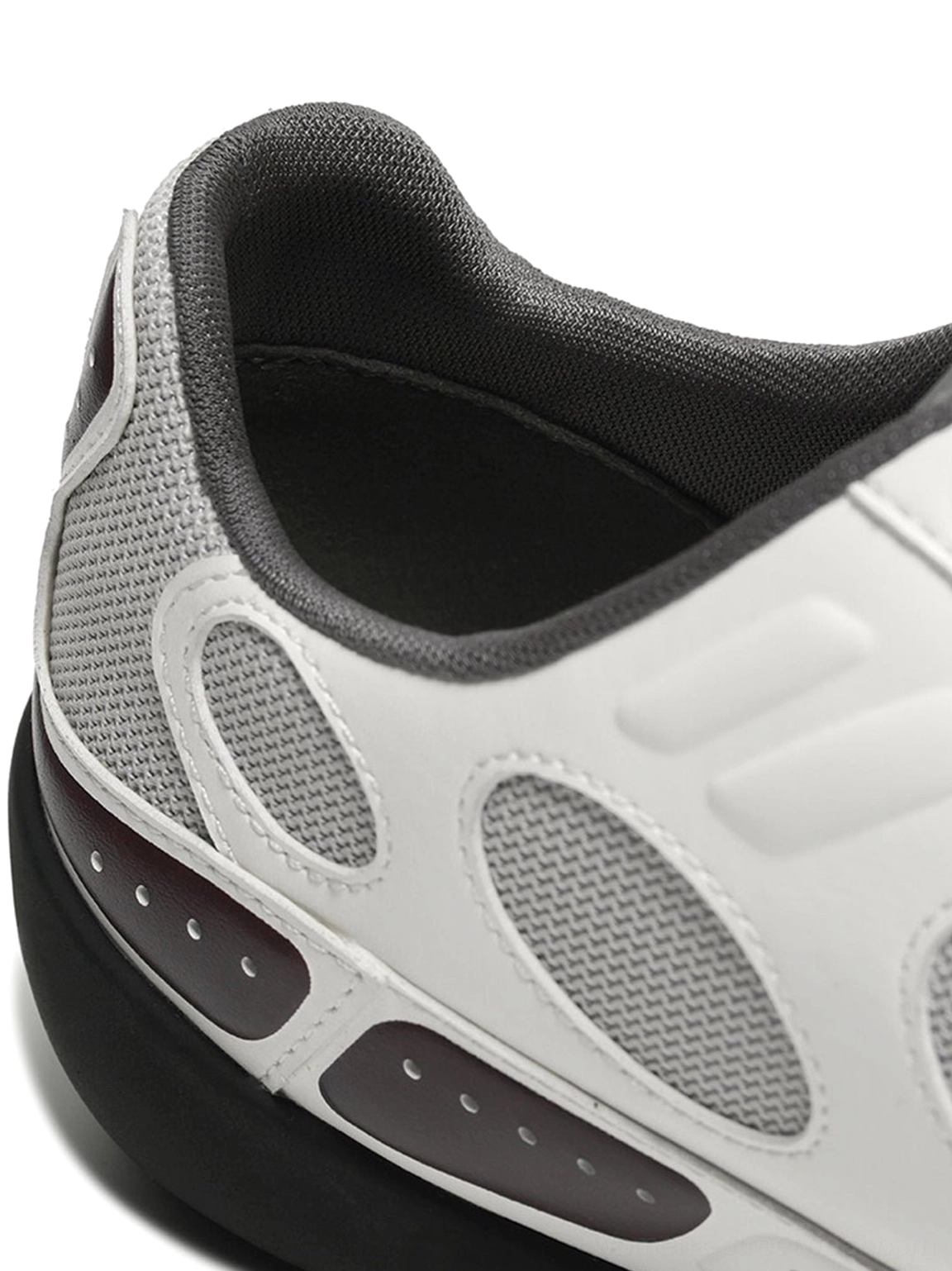 White perforated retro sport sneakers with burgundy contrast detailing and low profile streetwear outsole detail view