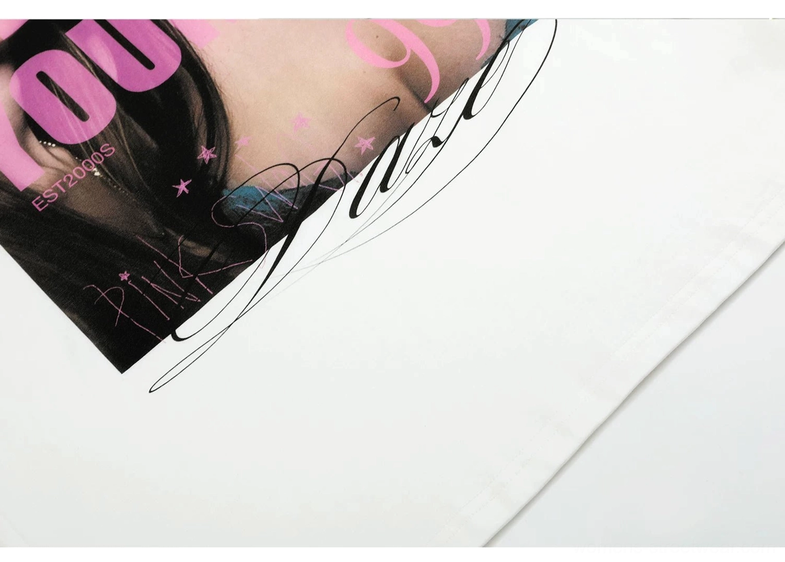 Close-up detail of white graphic T-shirt print featuring pink YOU lettering, star decorations, and PINK cursive text