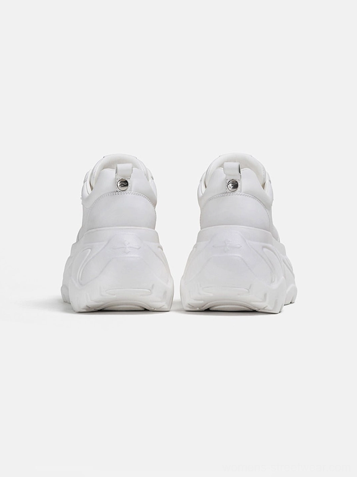 Rear close-up of white platform sneakers featuring a reinforced heel counter, pull loops, and bold sculpted rubber outsole