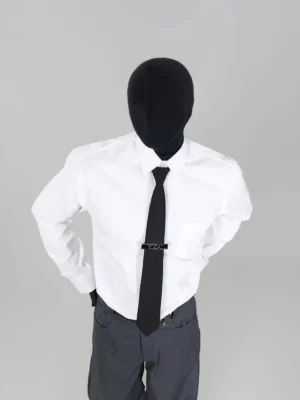White point-collar long-sleeve streetwear shirt styled with a silver tie clip and tailored gray trousers in a minimalist studio