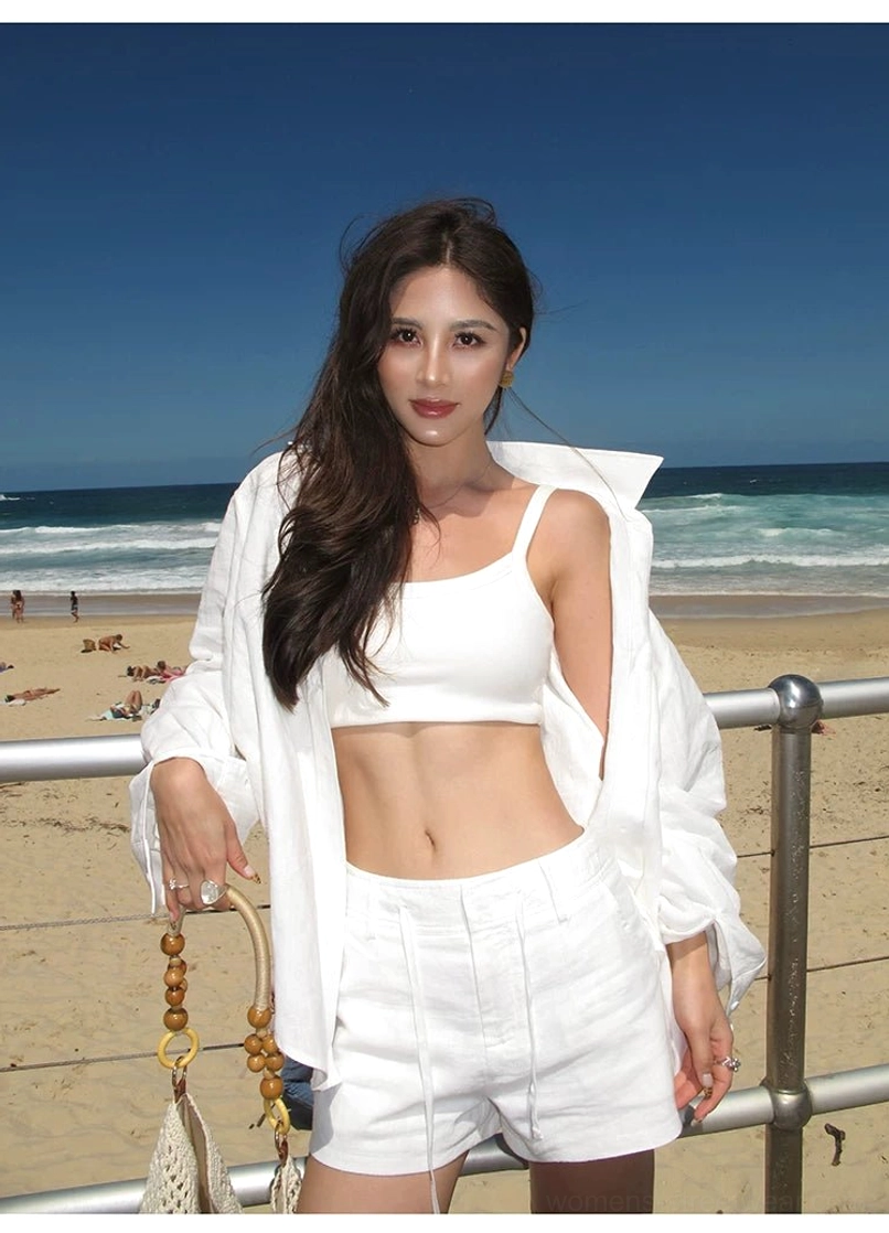 White ramie linen open oversized shirt over high-waisted shorts, seaside beach full-body shot with ocean and beachgoers
