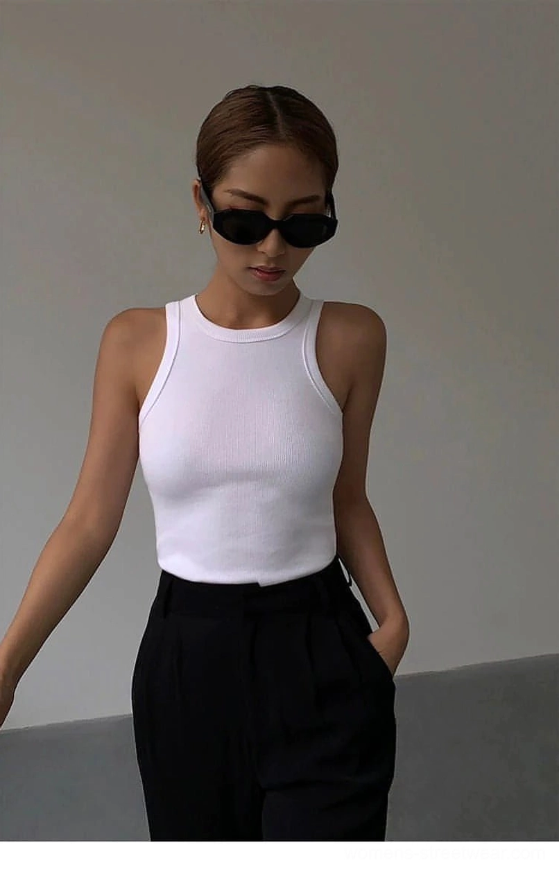 White ribbed knit tank top slim fitted silhouette on female model wearing black sunglasses, paired with black suit pants, minimalist aesthetic focus
