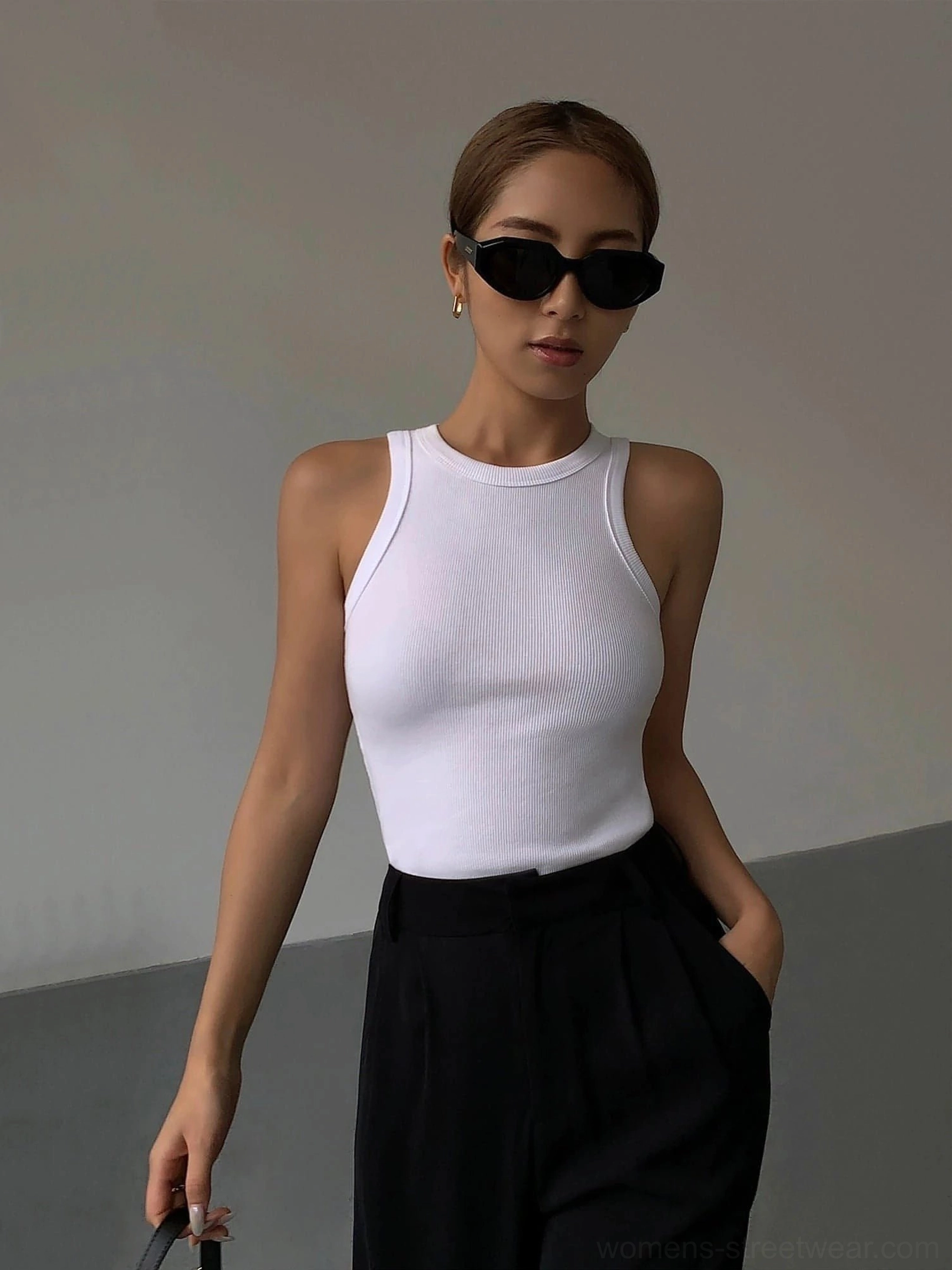 White ribbed knit tank top slim fit silhouette on female model wearing black sunglasses, matched with black suit pants and minimalist studio setting