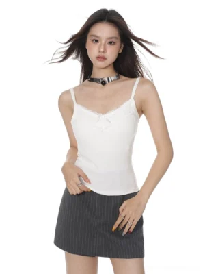 White ribbed lace trim camisole tank top with delicate V-neck and black chest bow styled with a gray pinstripe mini skirt