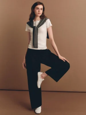 White ribbon lace retro trainers styled with casual workwear in a warm studio setting for women's streetwear fashion