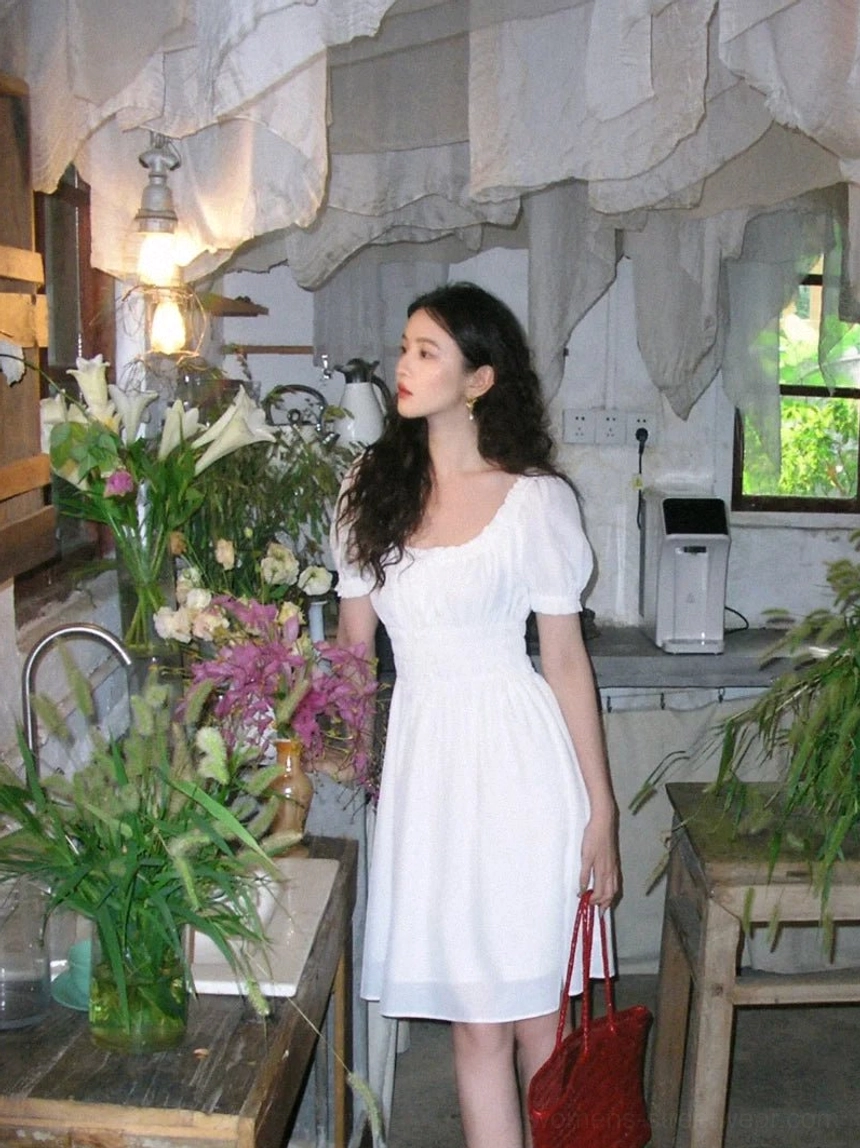 White romantic puff sleeve mini dress featuring a smocked waist, gathered square neckline, and solid A-line skirt in a vintage floral shop