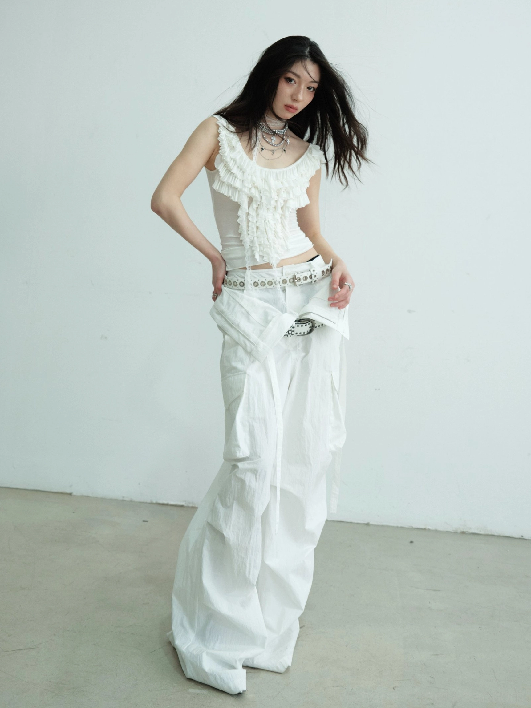 Back-side view of white sleeveless fitted tank top with clean scoop back and ruffled lace neckline detail