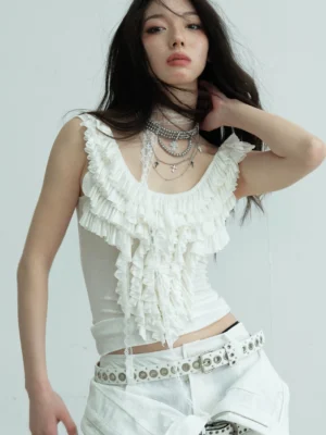 White ruffled lace scoop neck fitted tank top front close-up with layered silver necklaces and white cargo pants