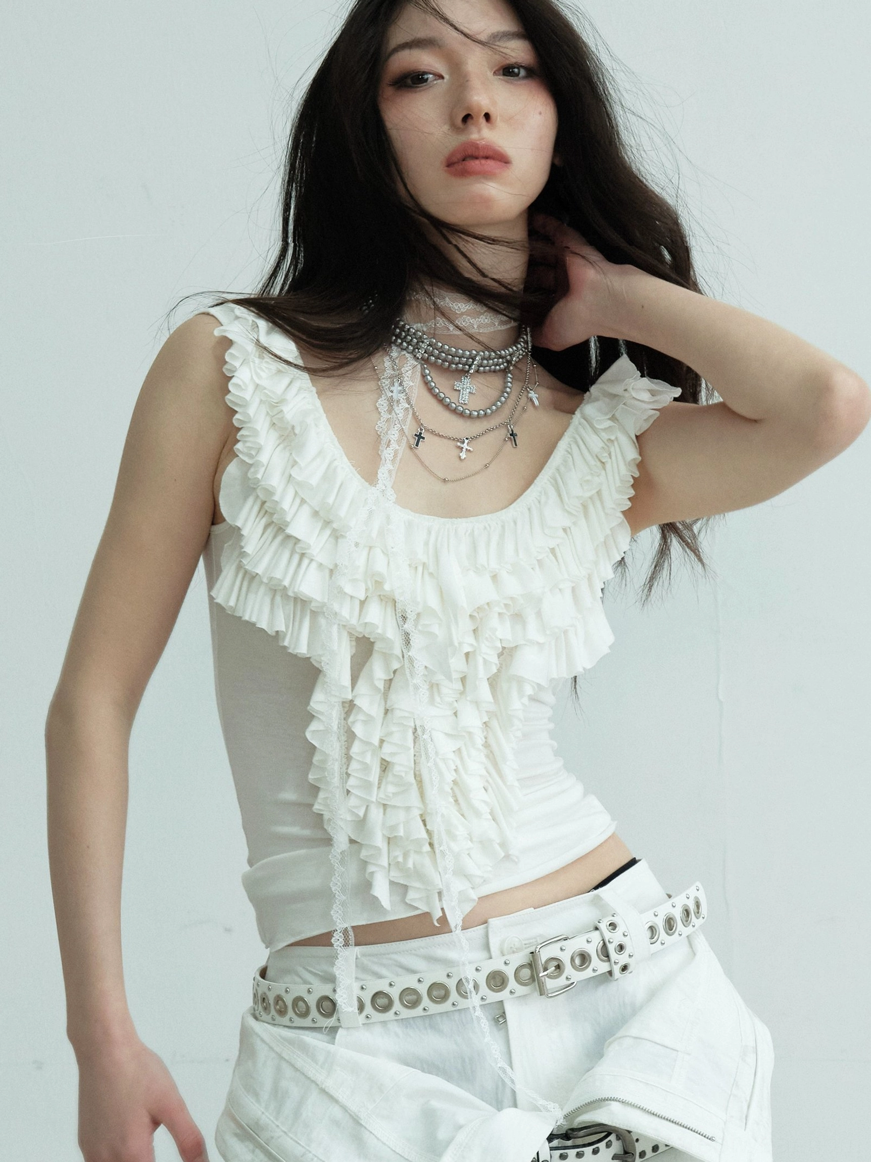 White ruffled lace scoop neck fitted tank top front close-up with layered silver necklaces and white cargo pants