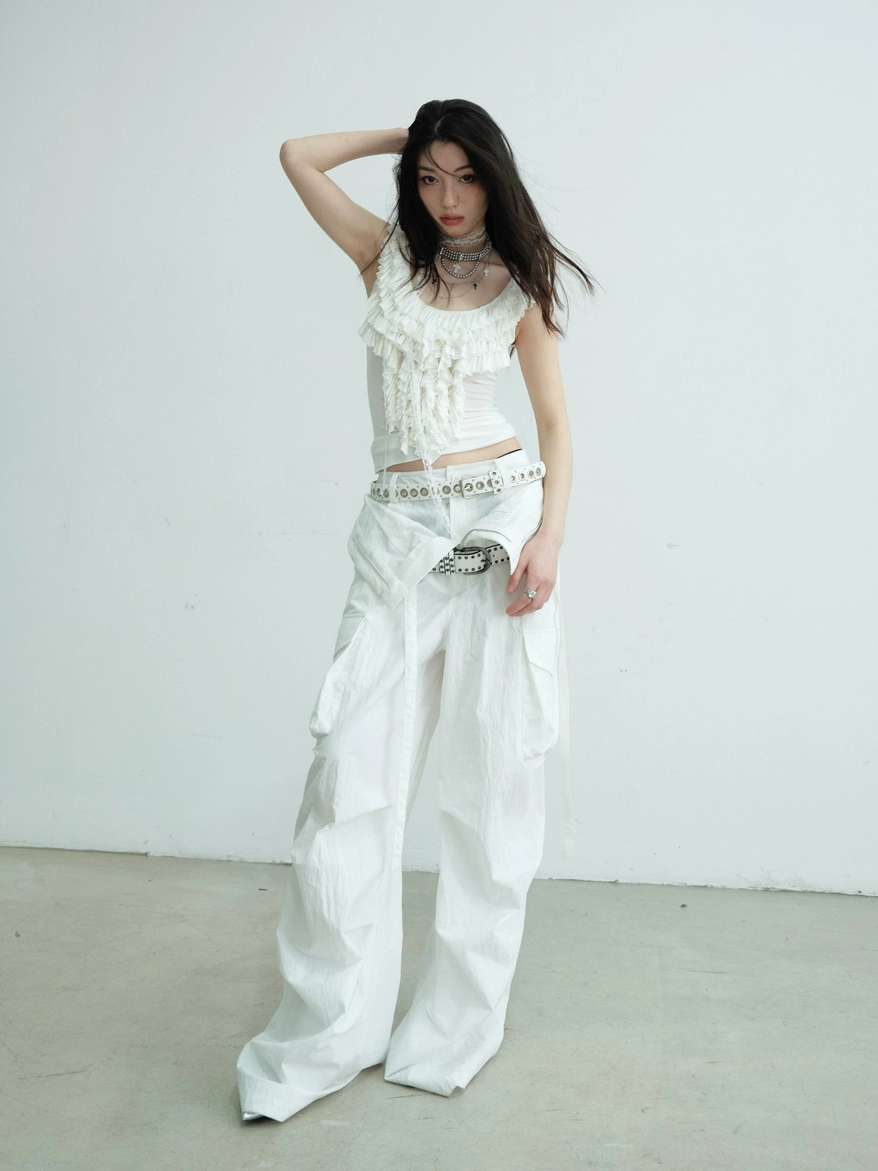 White ruffled lace fitted tank top styled with low-rise white cargo pants in a full-body front-side streetwear outfit
