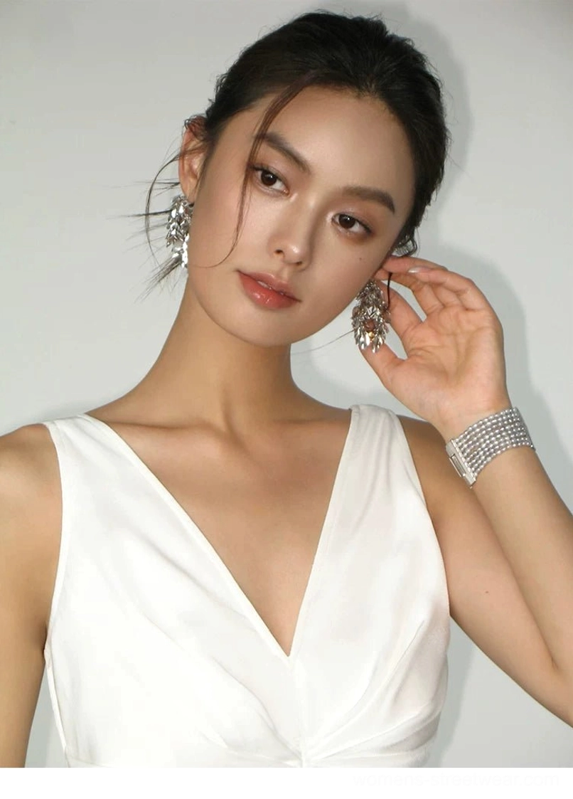 White satin sleeveless maxi dress upper-body portrait showing V-neckline, smooth glossy finish, minimalist silhouette and statement jewelry