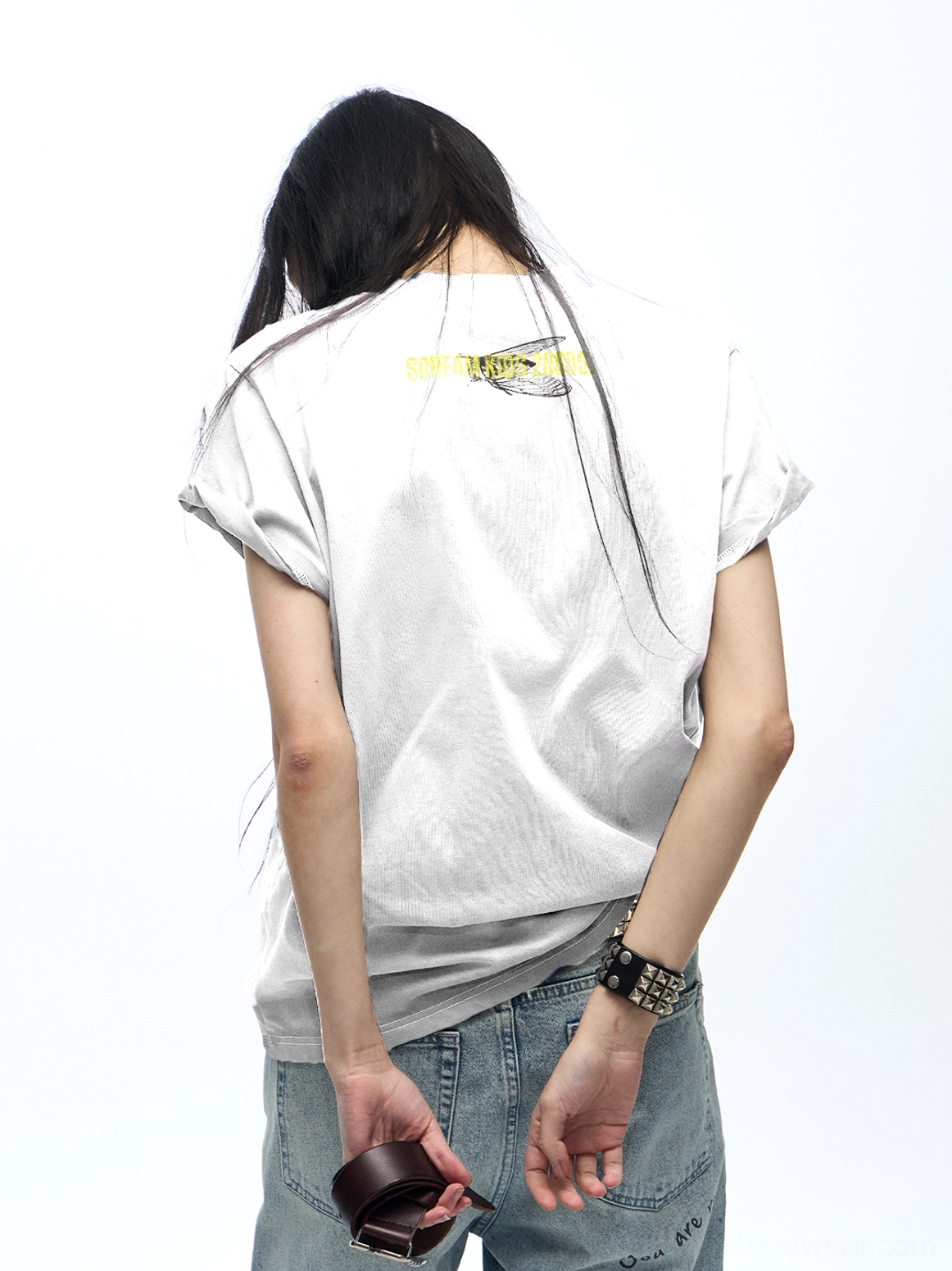 Back view of a female model wearing a white washed gradient Scream Kids T-shirt with a small yellow graphic at the back neckline