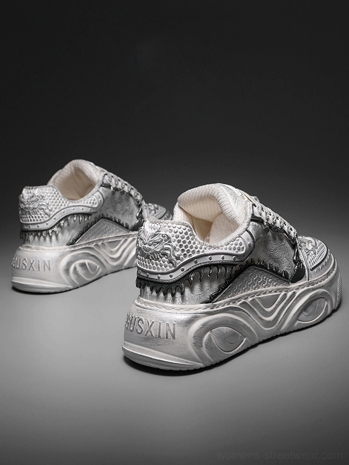 Rear view of white sculpted platform sneakers showing textured heel details, bone-inspired panels, and thick chunky soles