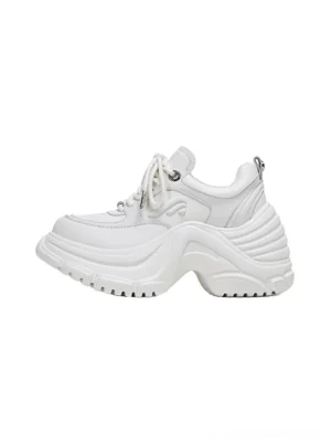 White sculpted wave chunky dad sneakers shown in a three-quarter studio view with layered upper panels, lace-up front, padded collar, and exaggerated wave-profile outsole