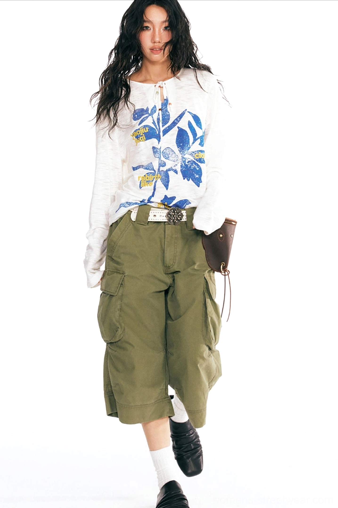 White drawstring neckline graphic tee styled with olive cargo pants leather shoes socks and a waist pouch