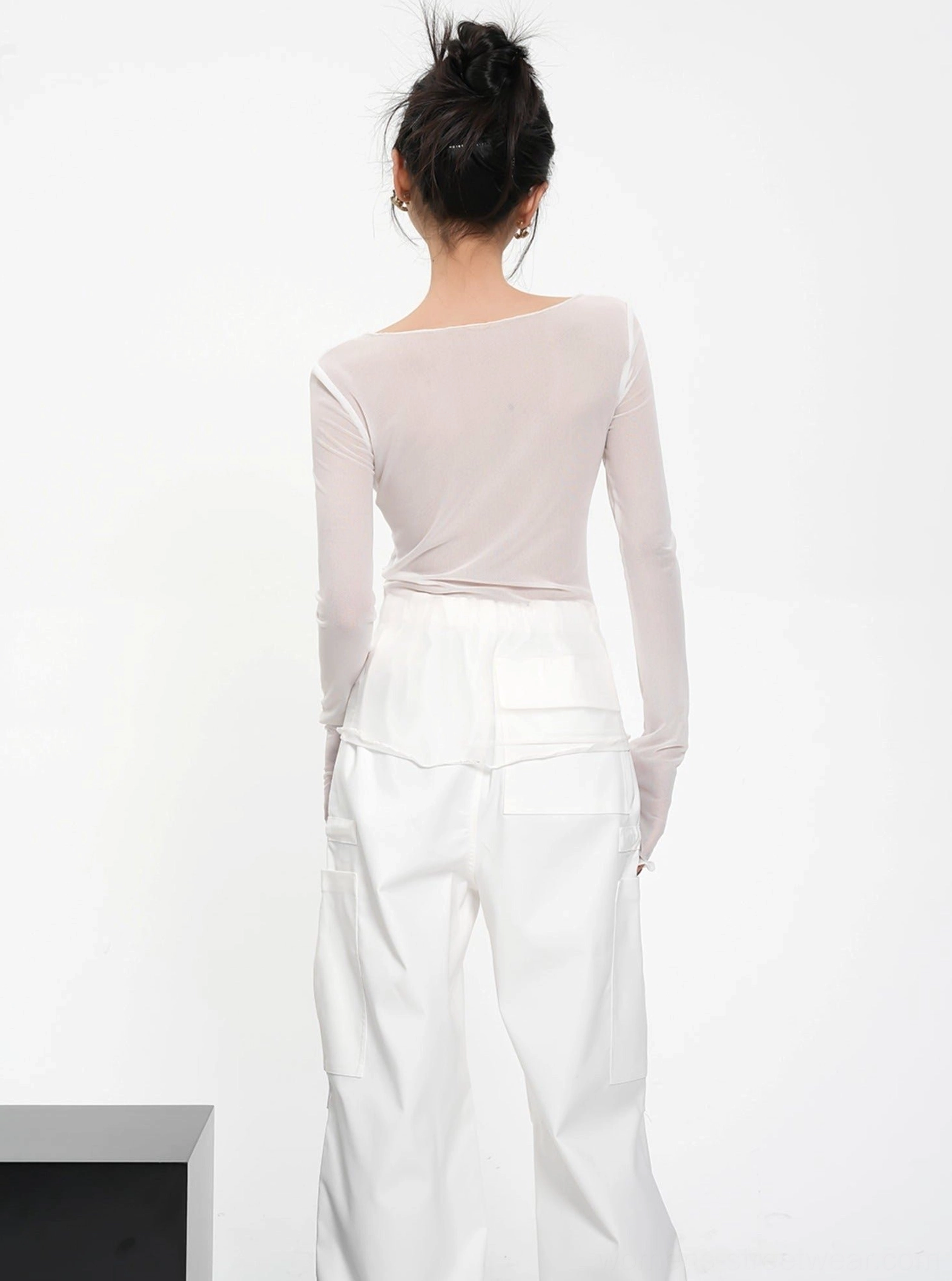 Back view of white sheer mesh long sleeve crop top showing cropped fit and translucent fabric