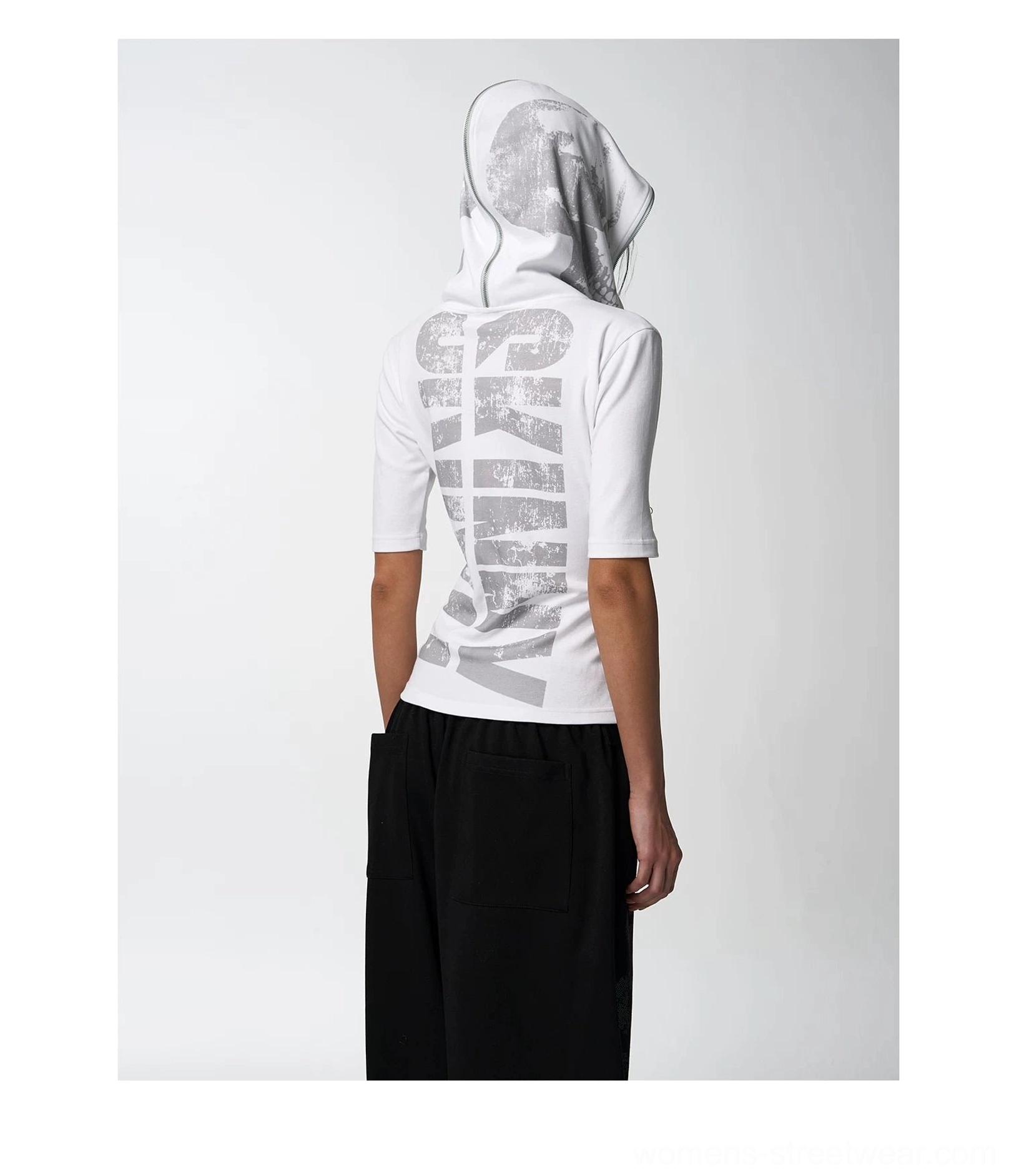 Back view of a white hooded graphic tee with bold SKINNY lettering and grey print styled with black bottoms