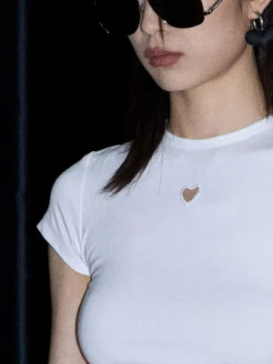 Close up of white fitted ribbed tee showing the subtle heart shaped chest detail and crew neckline