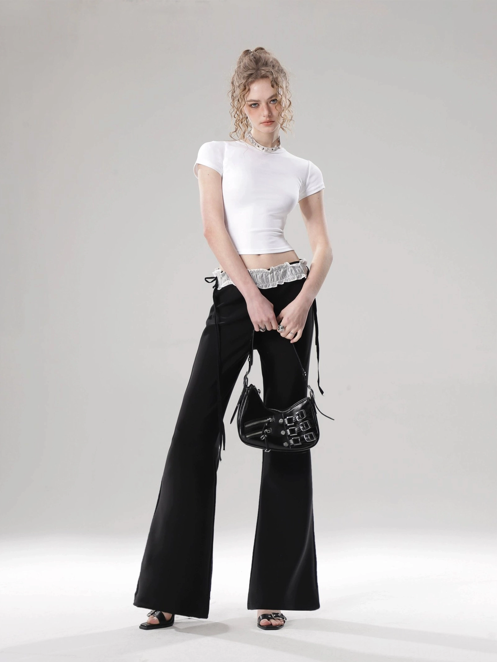 White solid color fitted cropped top with classic crew neck styled with black wide-leg pants and silver belt
