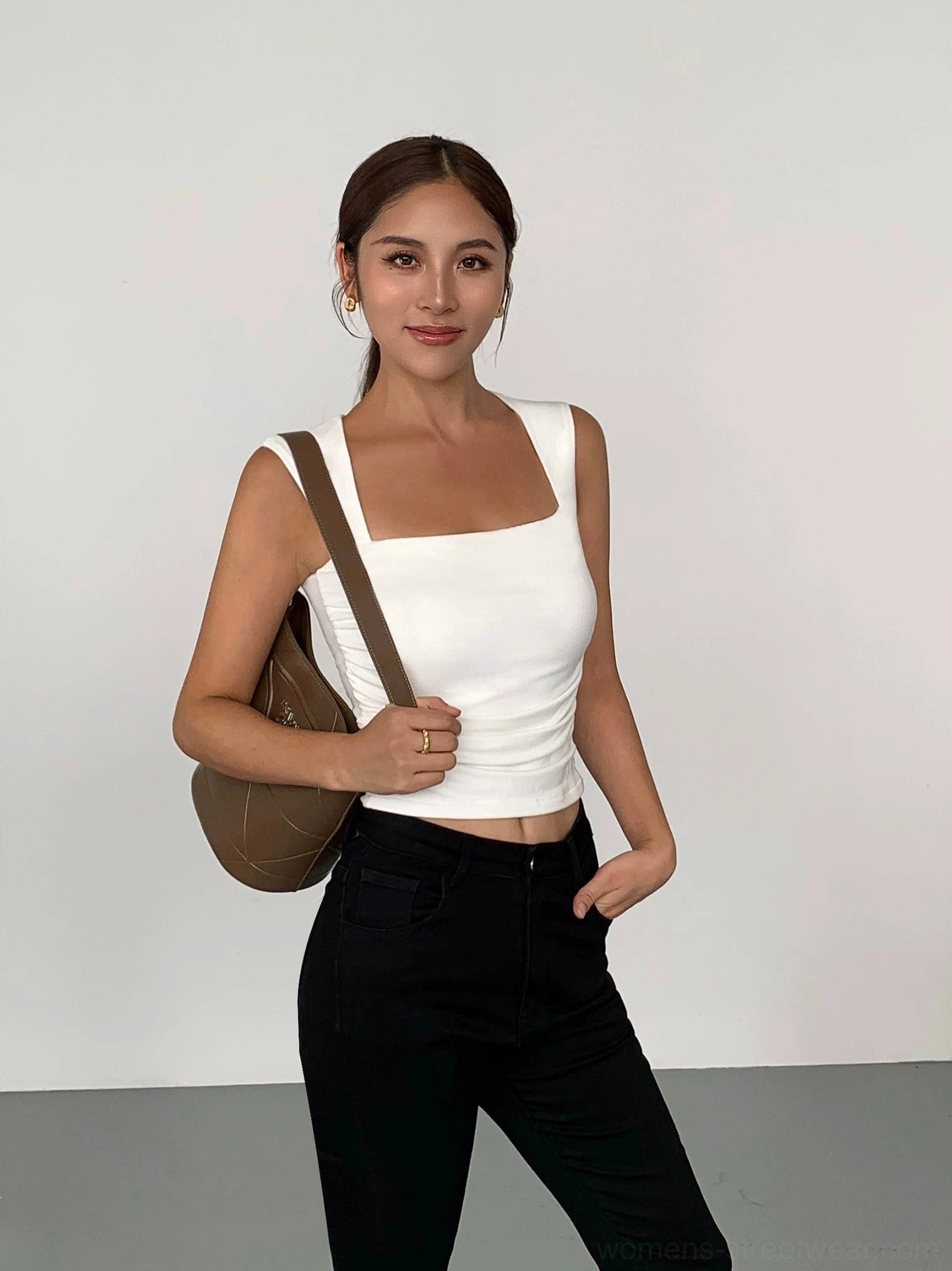White square neck cropped tank top styled with high waisted black pants and a brown leather shoulder bag