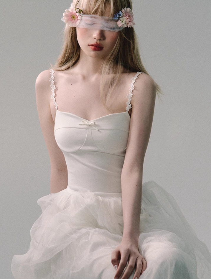 White sweetheart neckline tulle gown with delicate lace straps and flowing skirt styled as a modern romantic statement dress