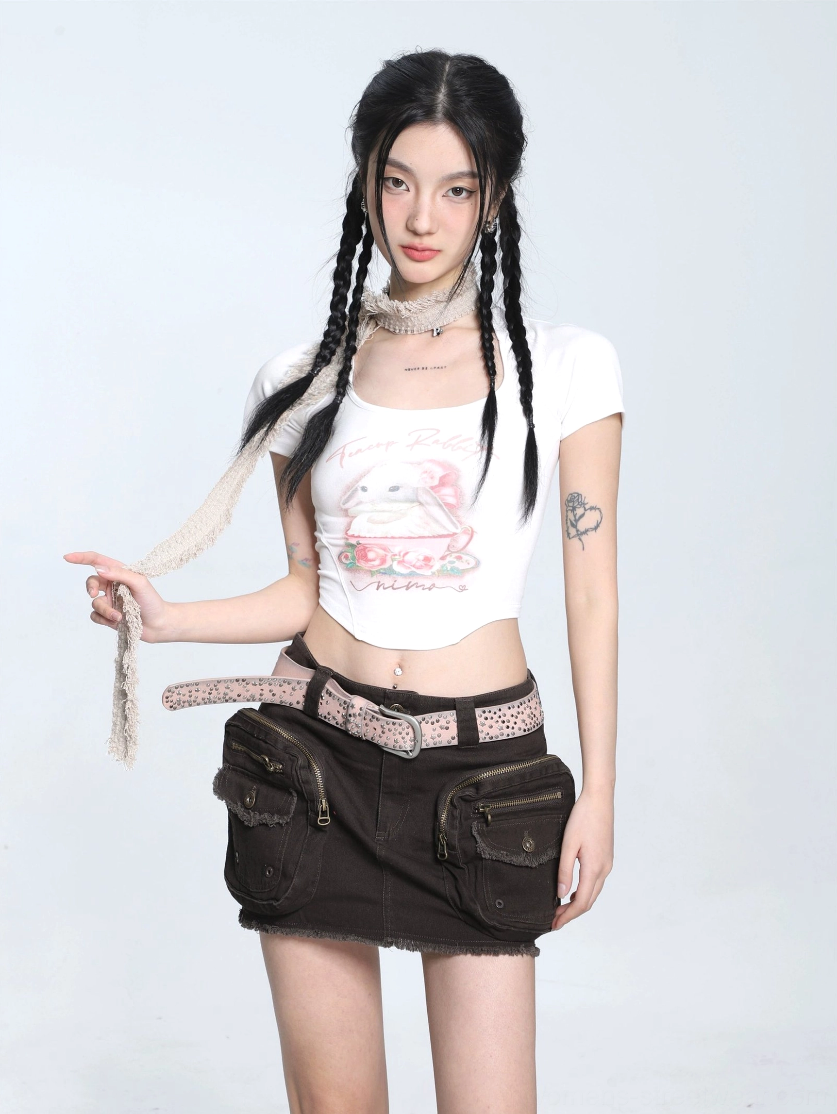 White cropped teacup bunny graphic T-shirt showing the curved hem and chest print with a brown cargo mini skirt and leopard belt