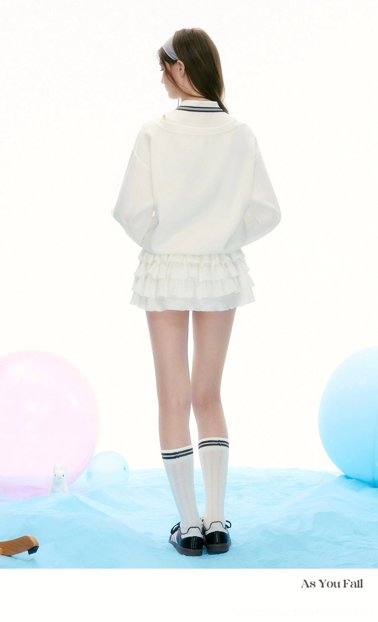 Back view of white tennis polo and layered ruffle mini skirt matching set with a clean sporty streetwear silhouette