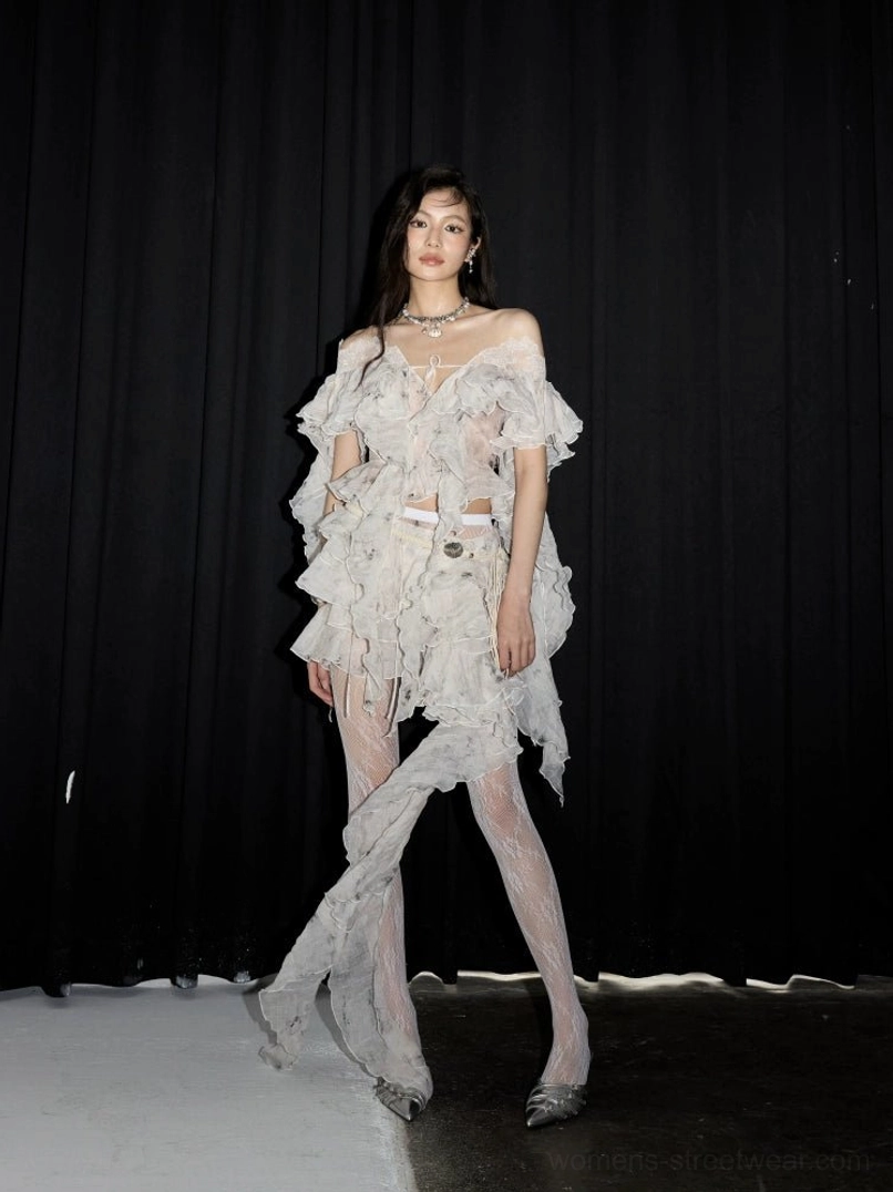 White tiered lace ruffle mini skirt styled with an off-shoulder top, sheer stockings, and silver heels