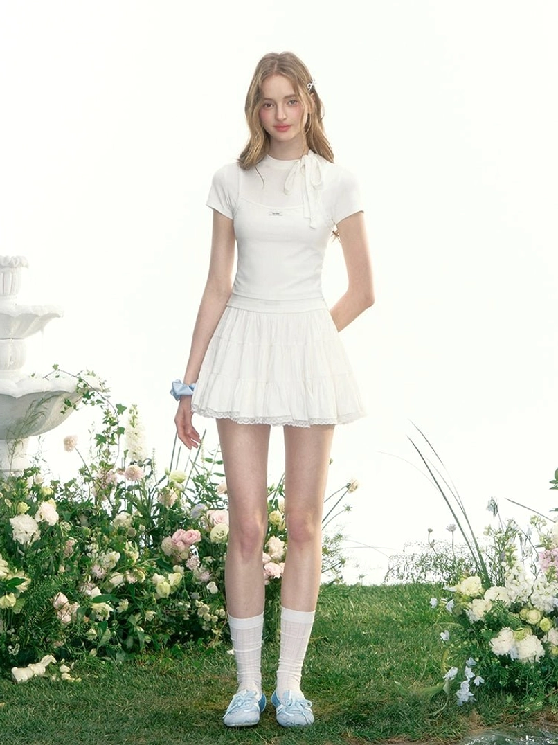 White tiered tennis mini skirt styled as a full Korean preppy tennis outfit with white socks and light blue loafers