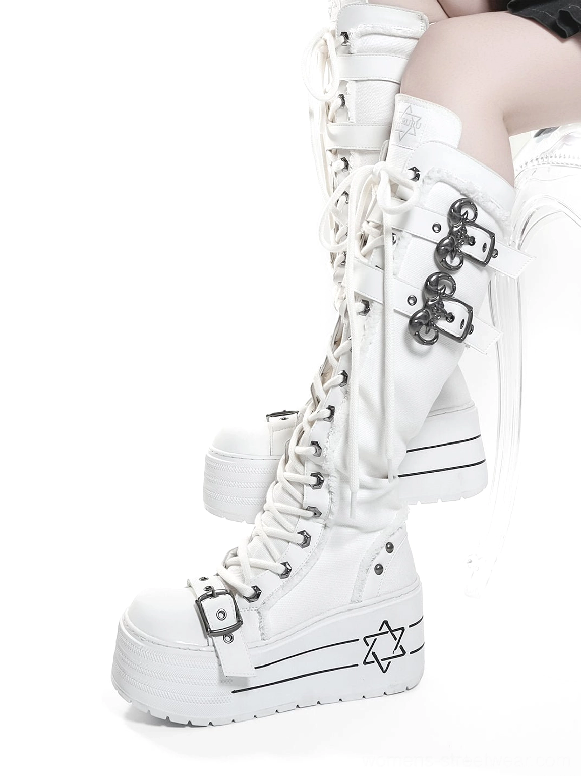 Side view of white triple-buckle knee-high platform combat boots worn in a gothic streetwear styling look