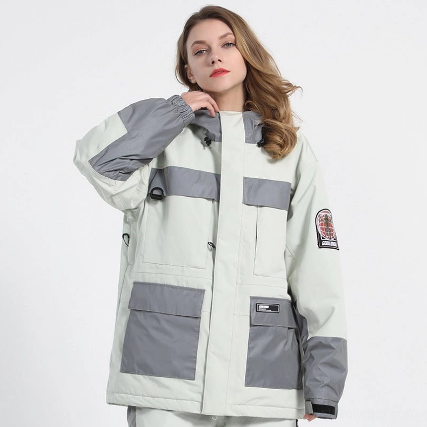White unisex reflective panel ski jacket in a light sage tone with grey color blocking, hood drawcord, chest reflective strips, and utility pockets