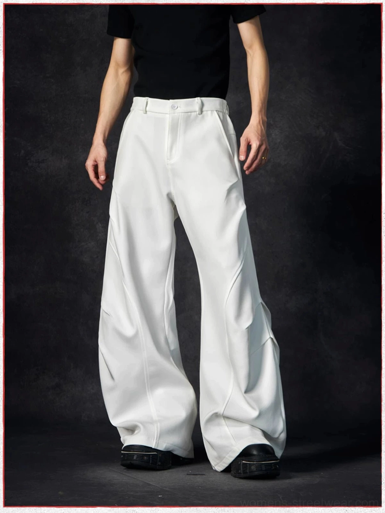 Low-angle front view of white wave contour streetwear trousers with zipper fly, button waistband, and floor-length wide legs