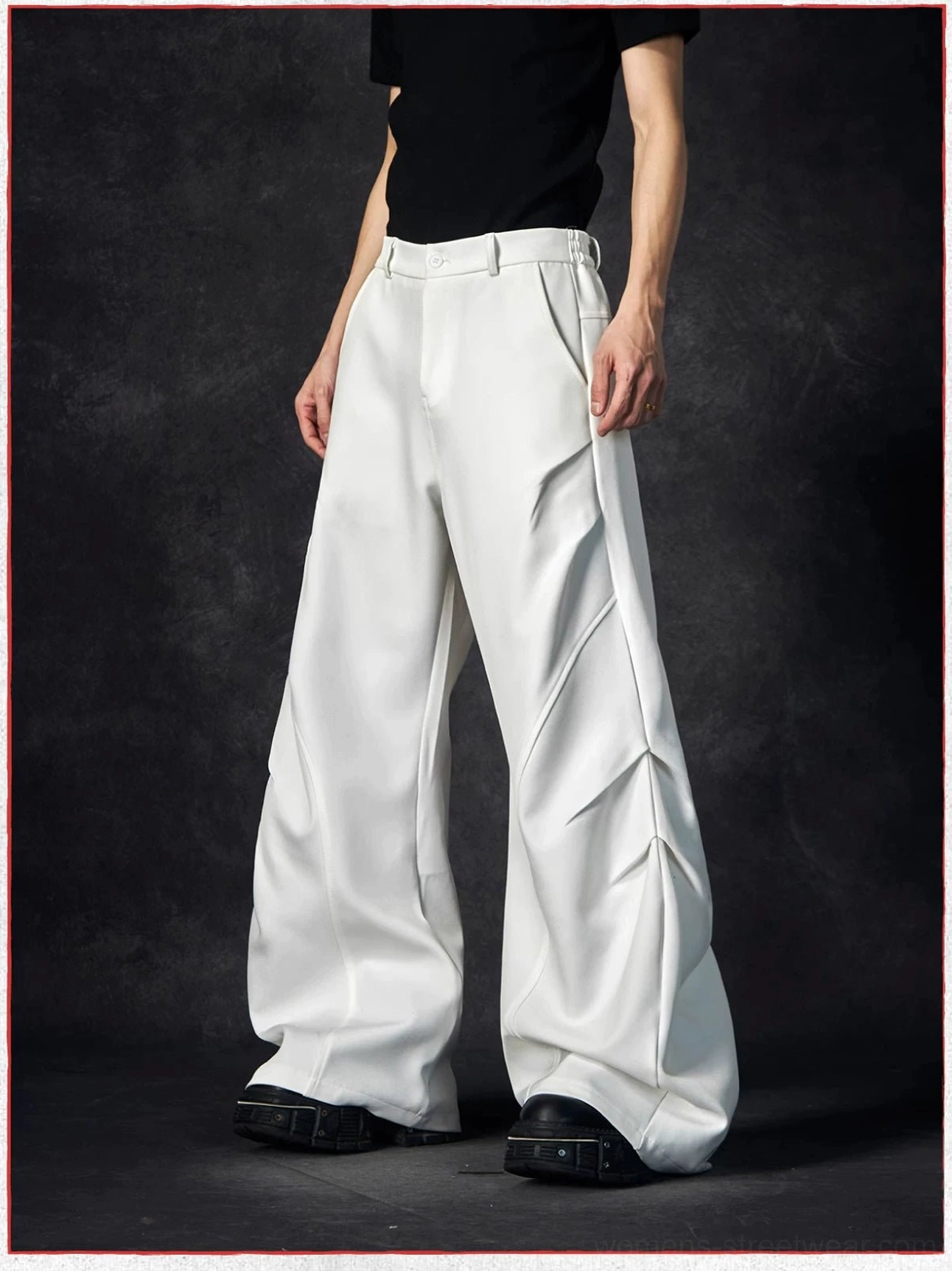 Side view of white wave contour wide-leg trousers showing the tailored waistband, curved side seams, and dramatic draped leg shape